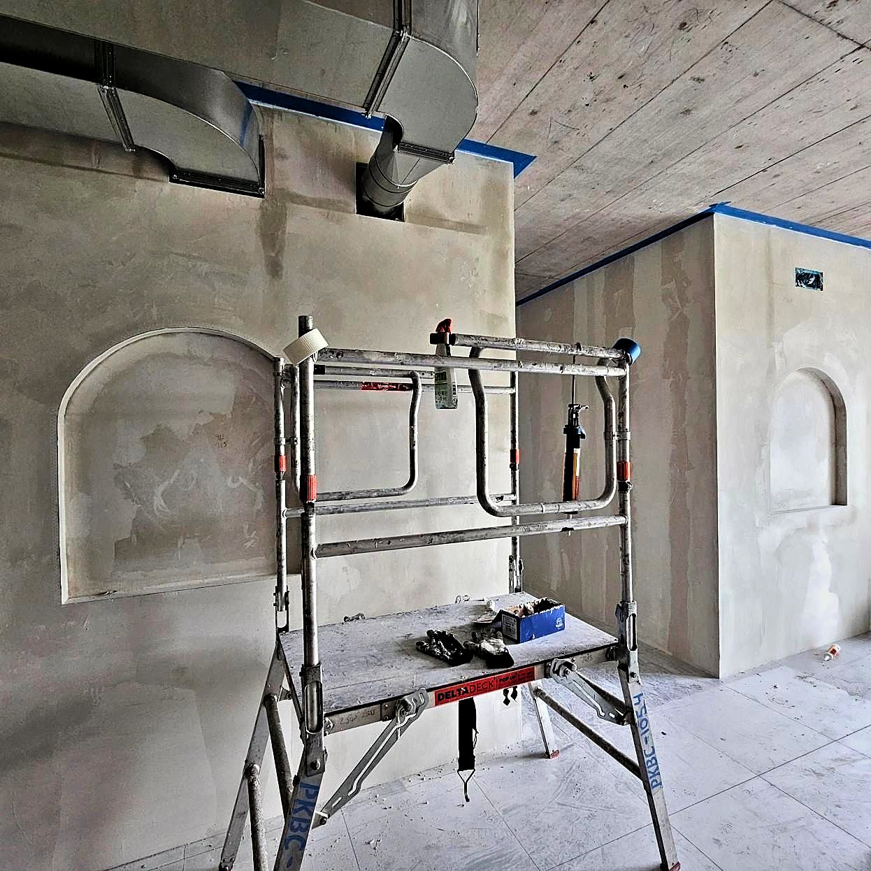 Plastered walls with arched niches during the studio fit-out