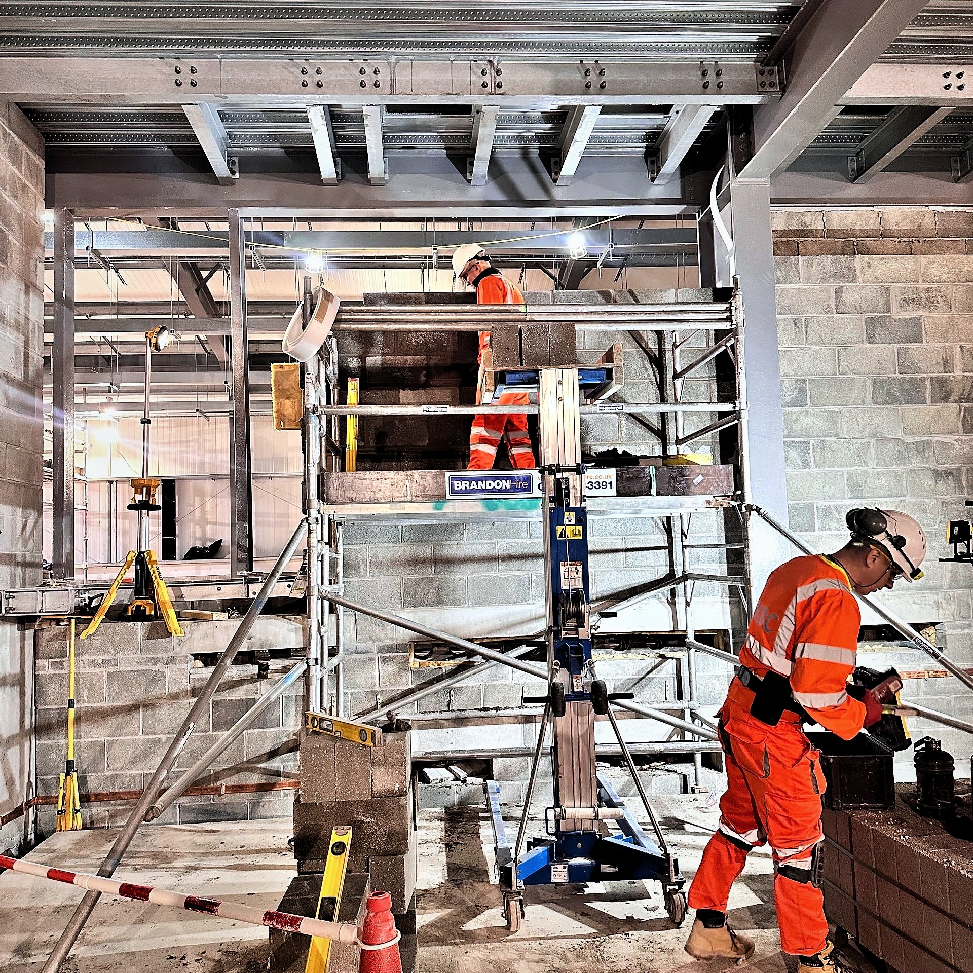 Blocklaying from scaffold towers inside a steel-framed substation building