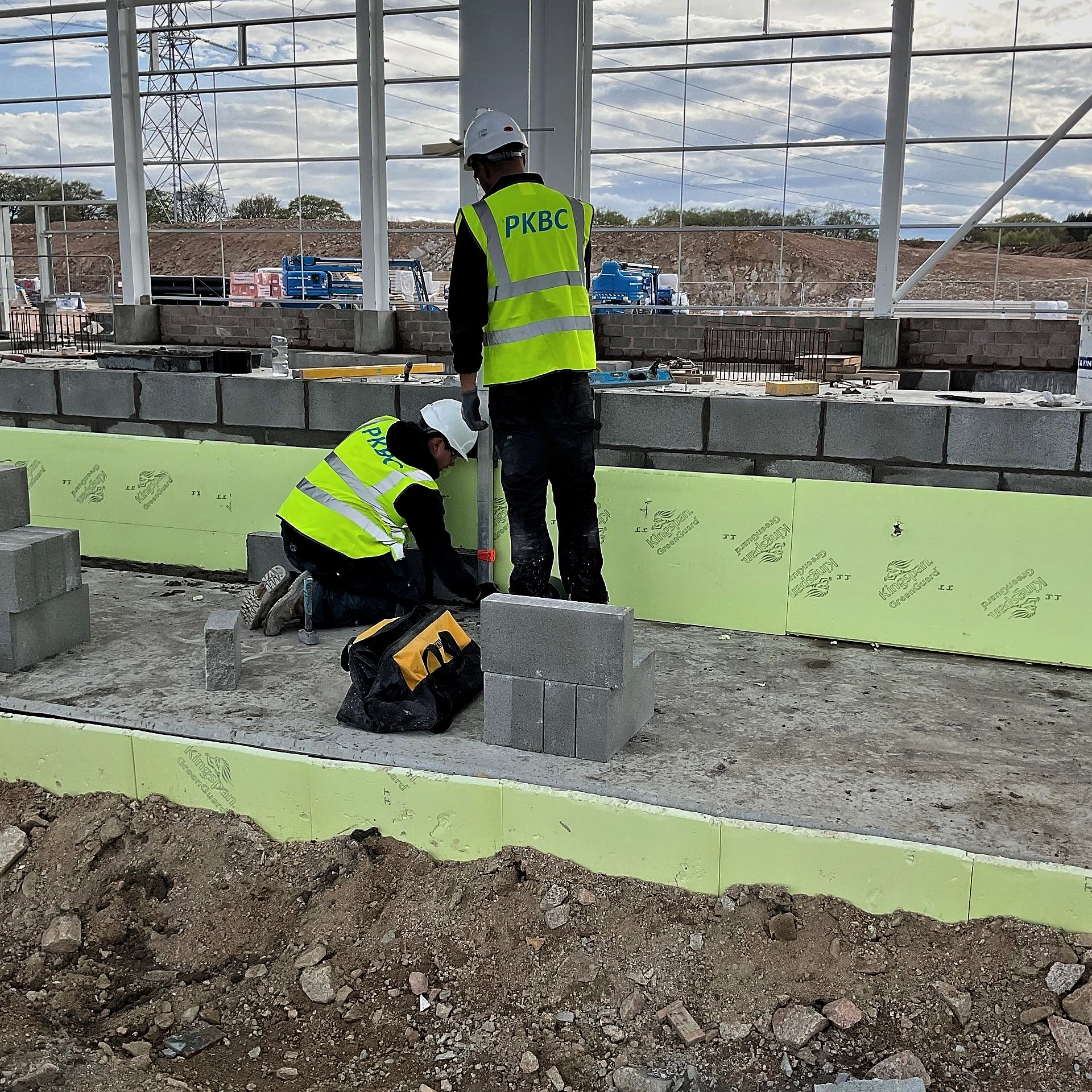 PKBC bricklayers setting out blockwork against insulation boards inside the steel frame at Kintore