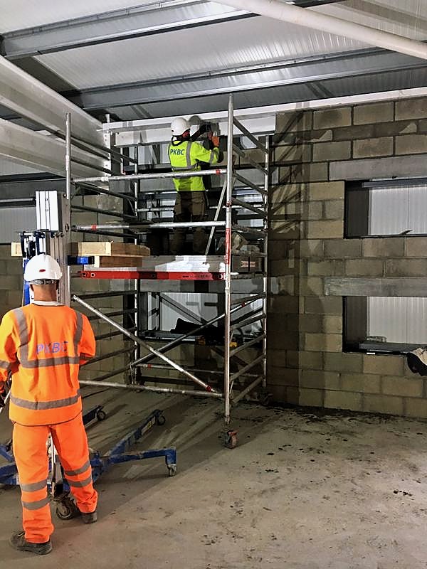 PKBC bricklayers working from a mobile tower on a blockwork wall with window openings