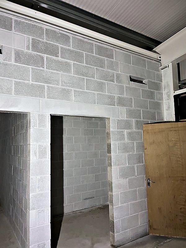 Finished fair-faced blockwork walls with door openings inside an industrial building