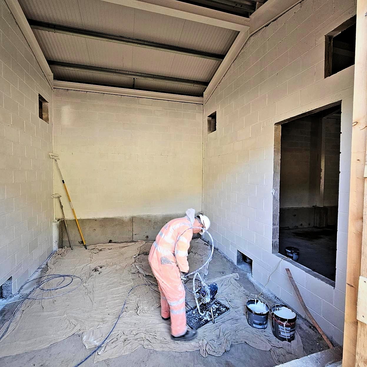 Spray painting the blockwork interior of the new substation building