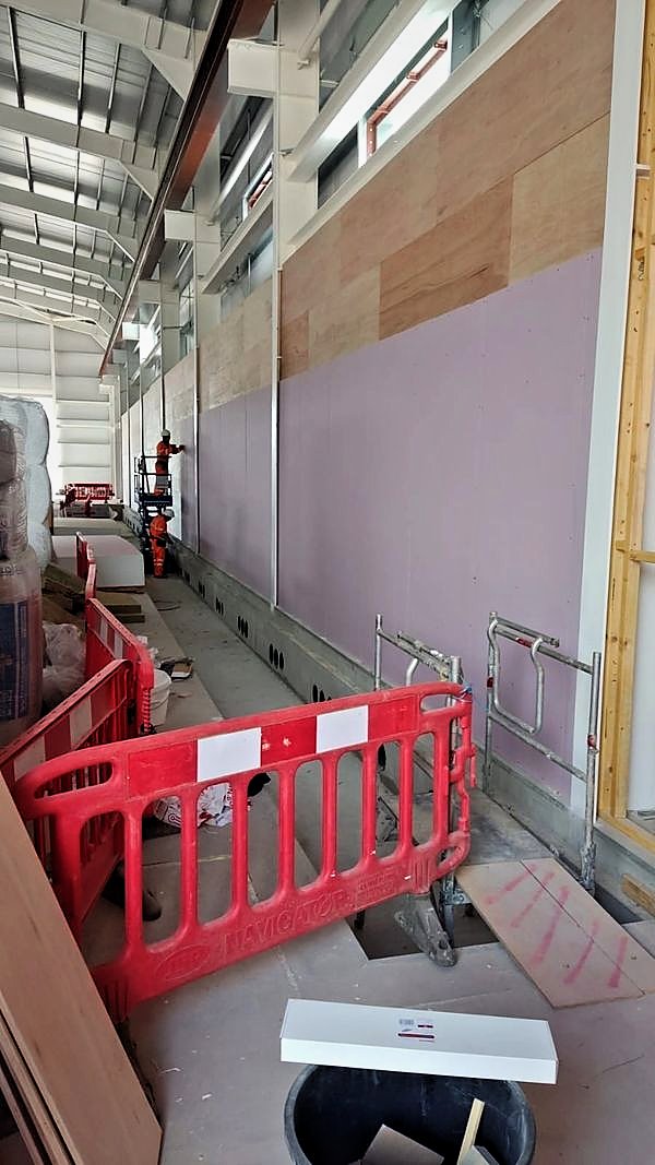 High wall lined with plywood and plasterboard, powered access alongside