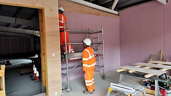 Operatives boarding a partition from a tower scaffold