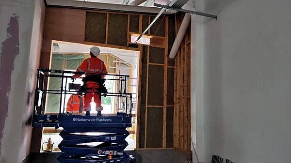 Insulated stud wall being lined beside a doorway