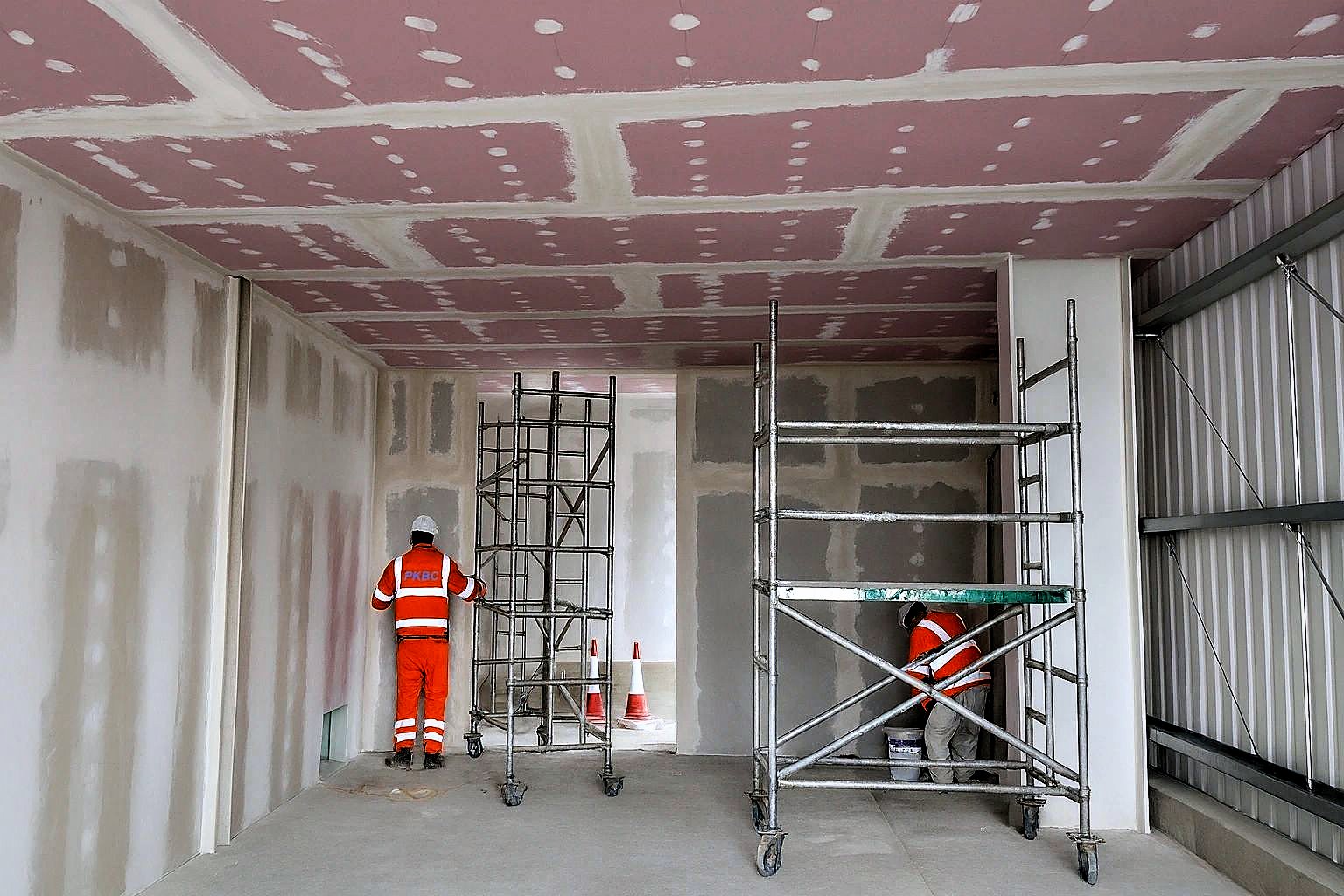Operatives jointing drylining beneath a fire-rated plasterboard ceiling at Rothienorman