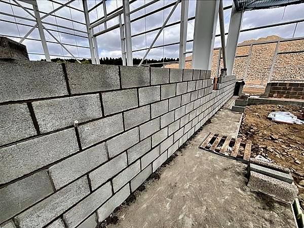 New blockwork wall running through an open steel frame