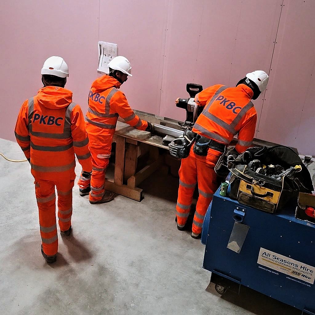 PKBC operatives cutting boards at a bench during internal fit-out