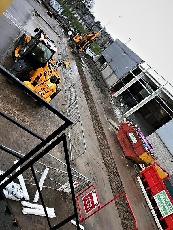 Telehandler and excavator on external works outside a commercial unit