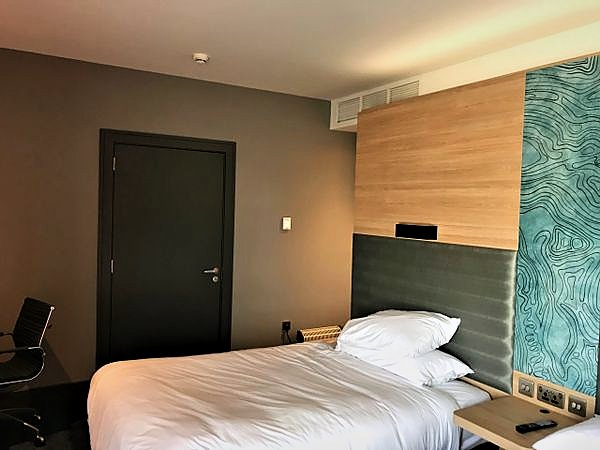 Completed hotel bedroom with timber headboard panelling and a feature wall