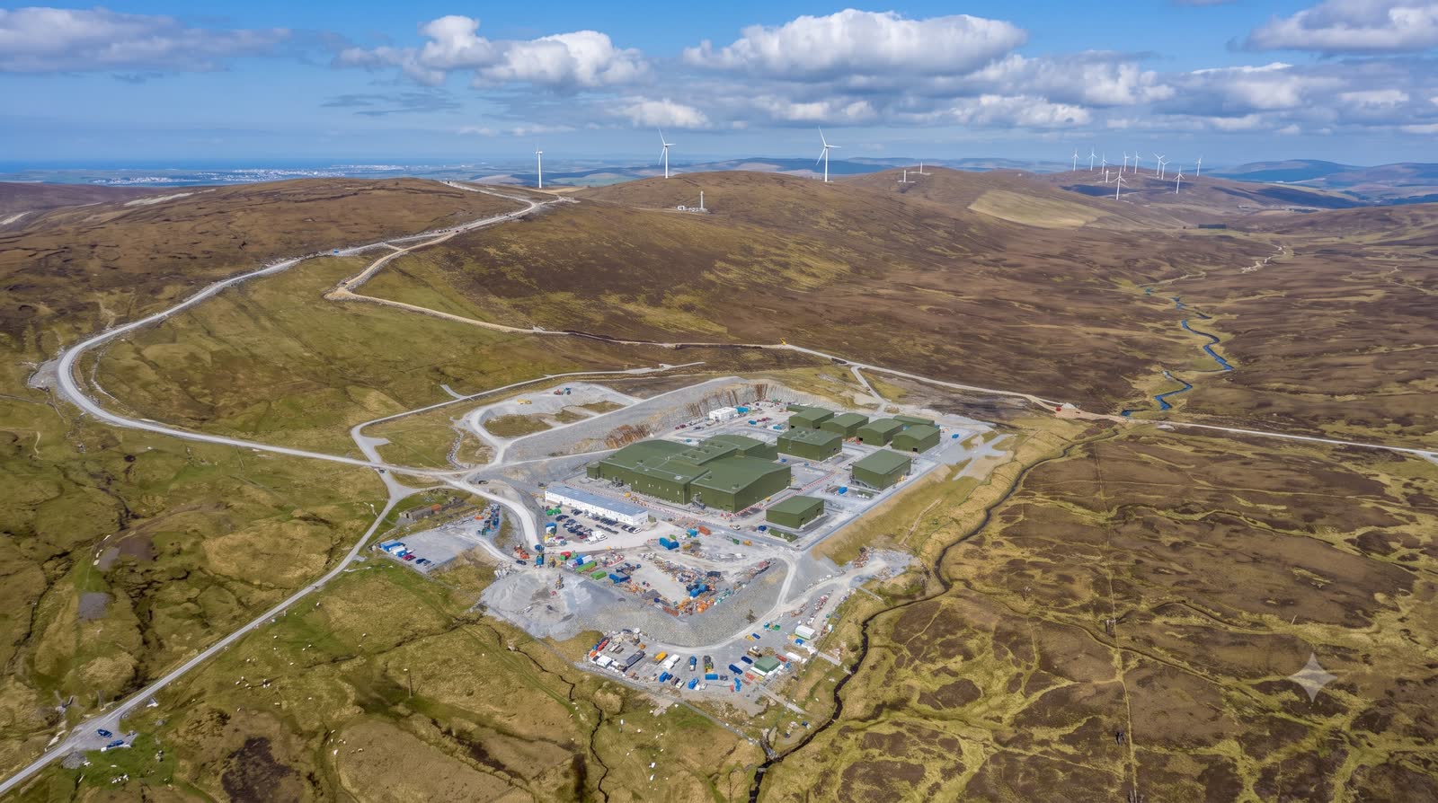 Aerial view of a completed substation with dark-green clad buildings in open moorland