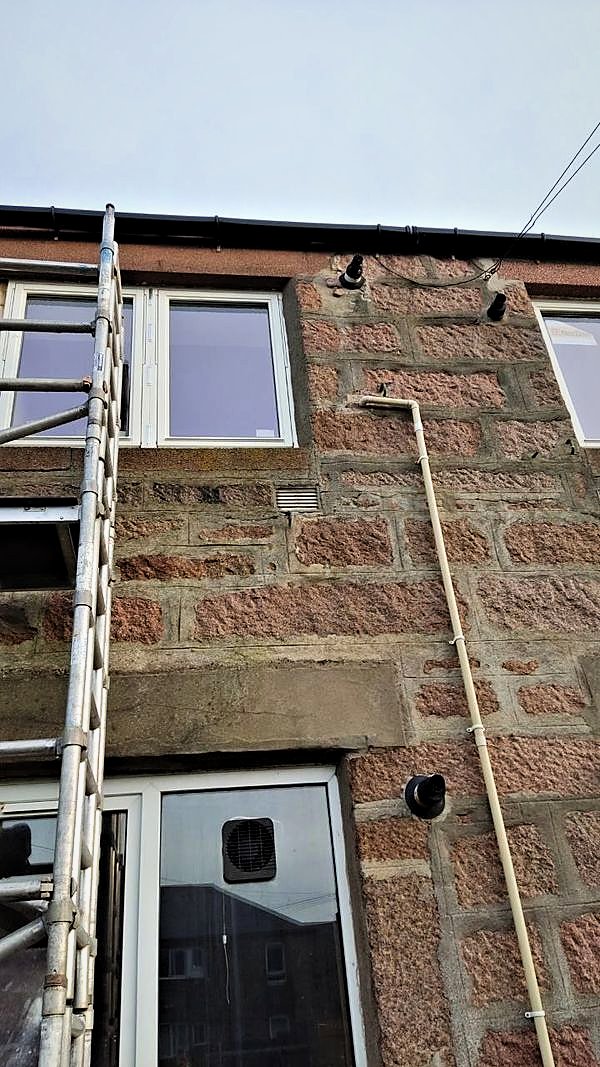 Tower scaffold against a granite property during window replacement