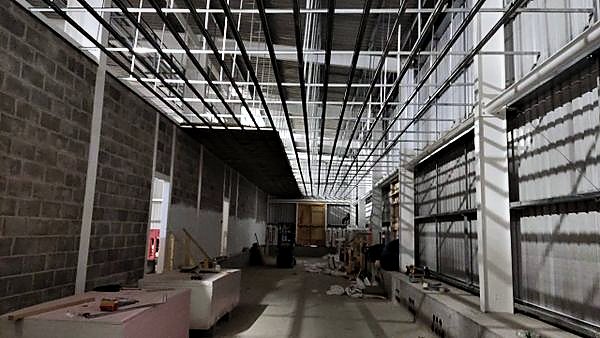 Fair-faced blockwork corridor walls beneath a suspended ceiling grid