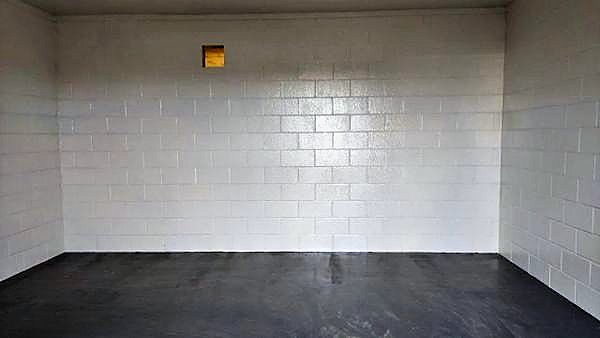 Blockwork walls painted white above a sealed grey floor