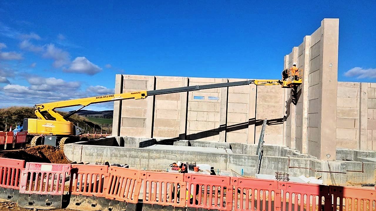 Telescopic boom reaching across a substation construction site