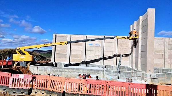 Telescopic boom reaching across a substation construction site