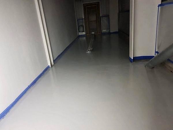 Finished light grey resin floor running through an internal corridor