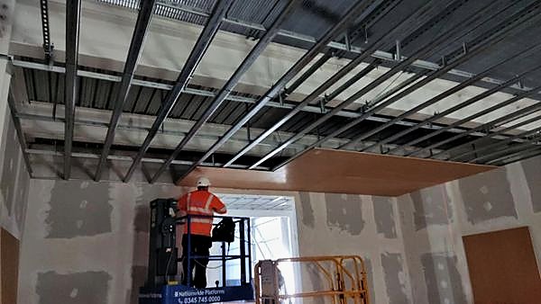 Metal ceiling framing installed overhead before boarding