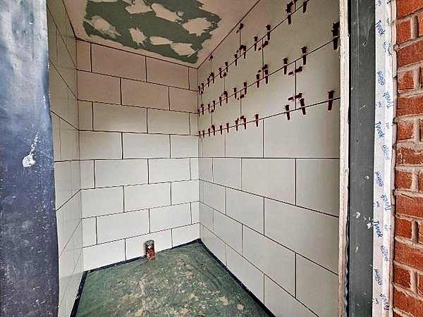 Wall tiling in progress with levelling clips still in place