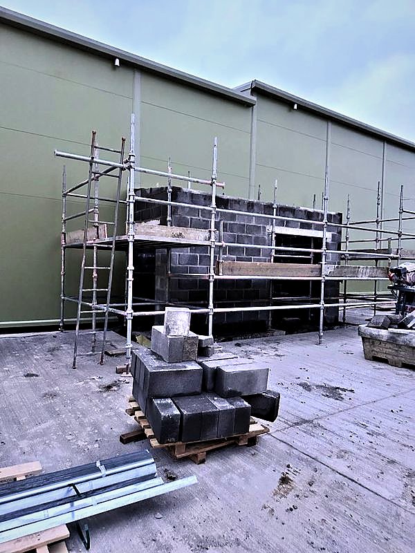 Independent scaffold around a blockwork structure beside a clad industrial building