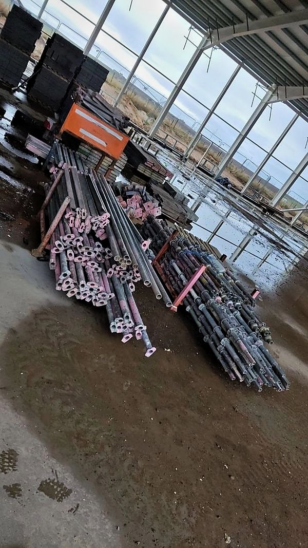 Scaffold components sorted and stacked inside a part-clad steel frame